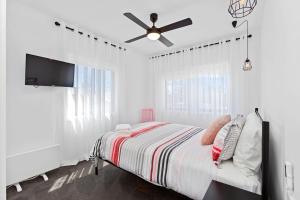 a white bedroom with a bed and a ceiling fan at Casino Views in Apollo Bay +16 photos