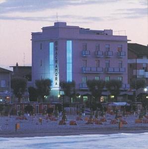 a building with a hotel with blue lights on it at Hotel Sacramora in Rimini