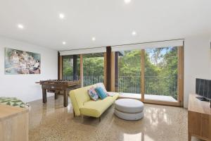 a living room with a yellow chair and a table at Clovelly - BYO Linen in Lorne