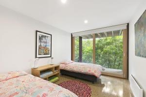 a bedroom with two beds and a window at Clovelly - BYO Linen in Lorne