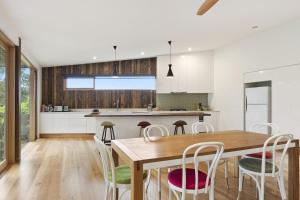a kitchen and dining room with a wooden table and chairs at Clovelly - BYO Linen in Lorne +5 photos