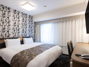 a hotel room with a bed and a desk at APA Hotel Osaka Higobashi Ekimae , All Rooms Non-Smoking in Osaka +80 photos
