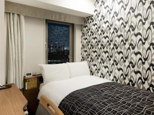 a hotel room with a bed and a window at APA Hotel Osaka Higobashi Ekimae , All Rooms Non-Smoking in Osaka