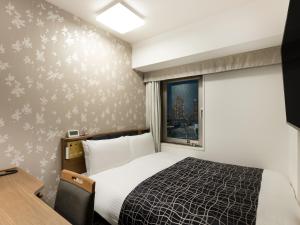 a hotel room with a bed and a window at APA Hotel Osaka Higobashi Ekimae , All Rooms Non-Smoking in Osaka