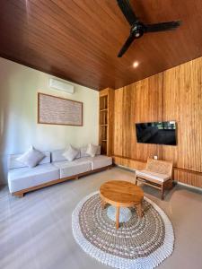 a living room with a couch and a table at Poka Ubud Hidden Paradise & Spa by EPS in Ubud