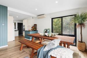 a kitchen and living room with a wooden table at Omaroo in Wye River +6 photos