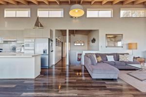 a living room with a couch and a kitchen at Otway Views in Apollo Bay