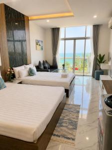 two beds in a hotel room with a view of the ocean at Ocean Vista Mai House in Ấp Phú Tịnh (2) +152 photos