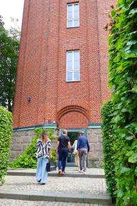 a group of people standing in front of a brick building at Ystads Gamla Vattentorn in Ystad