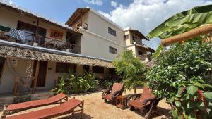 a courtyard with chairs and a building at Peace And Color Limited Guest House in Nungwi