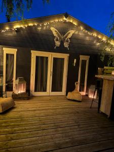 a porch with a butterfly on the side of a house with lights at Complete studio de Stopplaats dichtbij Hoorn en Alkmaar in Zuidermeer