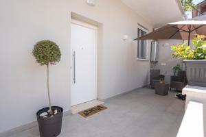 a hallway with a plant in a pot next to a door at Ramo D'oro Relax Apartments in Ariccia +5 photos