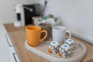 a tray with four coffee cups on a counter at Ramo D'oro Relax Apartments in Ariccia
