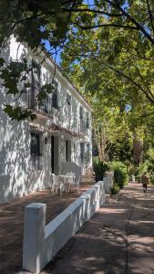 a white building with a table and chairs on a patio at Apartamentos Los Manueles in Tolox
