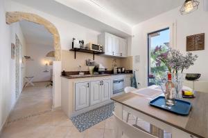 a kitchen with white cabinets and a counter top at Sicilian Sea Breeze - Apartment in Bagheria