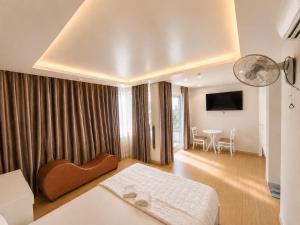 a hotel room with a bed and a dining room at LUNA Hotel in Ho Chi Minh City