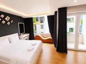 a bedroom with a white bed and a large window at LUNA Hotel in Ho Chi Minh City +16 photos