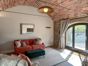 a living room with a red couch and a brick wall at The Lodge in Consett