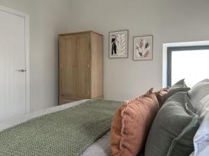 a bedroom with a bed and a wooden cabinet at The Lodge in Consett