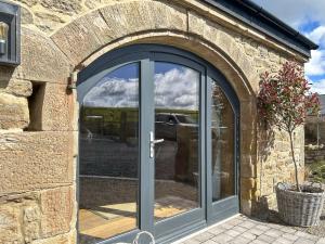 an entrance to a stone building with a glass door at The Lodge in Consett +3 photos