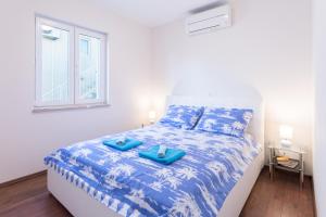 a bedroom with a bed with blue sheets and a window at Mladinic Palace in Milna
