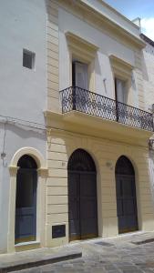 ガラティーナにあるKaleidos Guest Houseの3つのドアとバルコニー付きの大きな建物