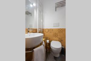 a bathroom with a white sink and a toilet at Kaleidos Guest House in Galatina