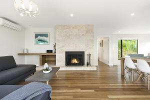a living room with a couch and a fireplace at Vue Sur La Mer in Wye River
