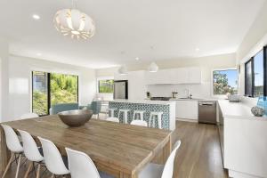 a kitchen and living room with a wooden table and chairs at Vue Sur La Mer in Wye River +16 photos