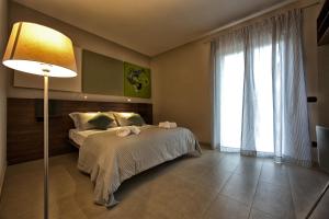 1 dormitorio con cama, lámpara y ventana en Lepini Suites, en Patrica