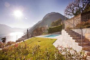 a house with a swimming pool next to the ocean at Argegno Pool apartment by Italian Apartments in Argegno