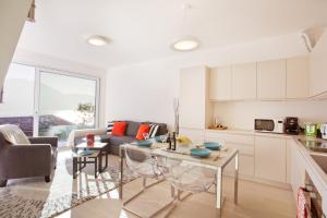 eine Küche und ein Wohnzimmer mit einem Tisch und einem Sofa in der Unterkunft Argegno Pool apartment in Argegno