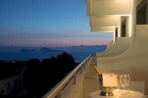 a bottle of champagne and two glasses on a balcony at Hotel Marad in Torre del Greco