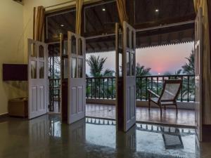 an open door to a balcony with a chair at SaffronStays Salt Rim on the Beach, Korlai in Christpāda +34 photos