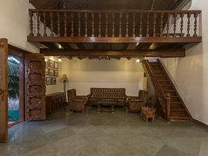 a living room with a staircase and chairs at SaffronStays Salt Rim on the Beach, Korlai in Christpāda