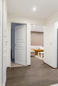 einen Flur mit einer weißen Tür und einem Wohnzimmer in der Unterkunft Marja Apartment in Põltsamaa