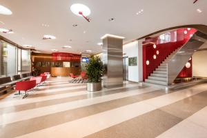 a lobby with a staircase and red chairs at Hotel Ambassador in Bern