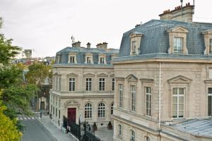 a large building with a red door on a street at La Chambre du Marais in Paris