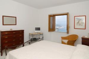 a bedroom with a bed and a dresser and a window at Casa Marechiaro in Conca dei Marini