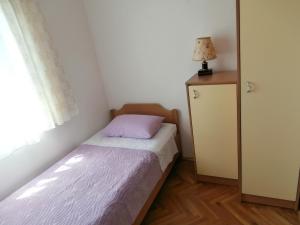 a small bedroom with a bed and a window at Panorama Postira Apartments in Postira