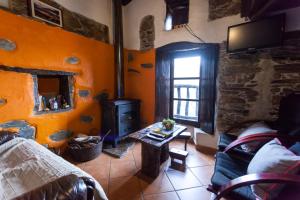 a living room with a wood stove in a room at Talasnal Montanhas de Amor in Lousã