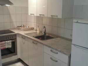 a white kitchen with a sink and a refrigerator at Studio Cres in Cres +7 photos