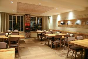 a restaurant with wooden tables and chairs and windows at Landhotel Gasthof Willecke in Sundern
