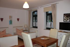 a living room with a table and a dining room at Internationales Gästehaus Leipzig in Leipzig