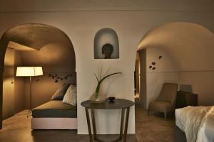 um quarto de hotel com uma cama e uma mesa em Sikelia Luxury Hotel em Pantelleria