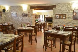 a restaurant with wooden tables and chairs and a stone wall at Agriturismo Girolomoni - Locanda in Isola del Piano