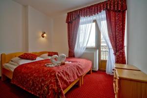 sypialnia z łóżkiem z czerwonym kocem i oknem w obiekcie Pod Tatrami 2 - świetna lokalizacja, blisko największych atrakcji oraz restauracji w mieście Białka Tatrzanska