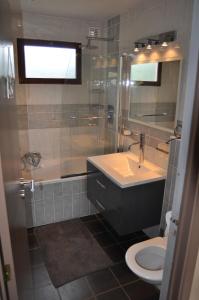 a bathroom with a sink and a tub and a toilet at Chalet Ardenne Mini in Rochehaut