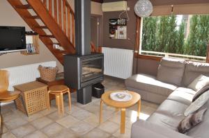 a living room with a couch and a stove at Chalet Ardenne Mini in Rochehaut