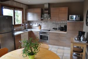 a kitchen with wooden cabinets and a wooden table with a tableablish at Chalet Ardenne Mini in Rochehaut